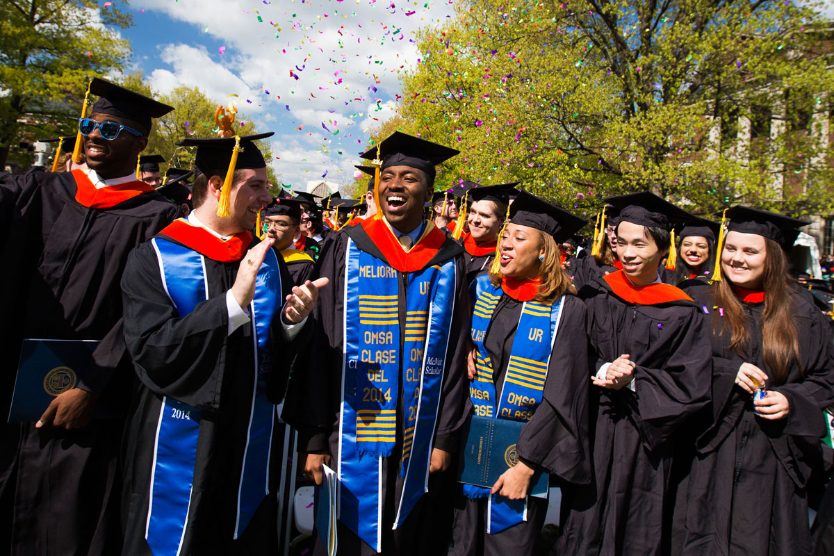 A group of University of Rochester graduates proudly wearing their graduation robes and caps, celebrating their achievement.