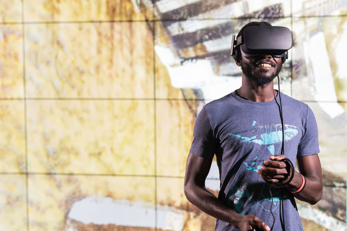 A man at the University of Rochester engages with a virtual reality headset, immersed in a digital experience.