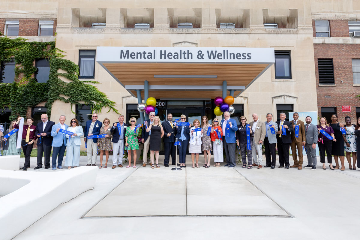 diverse group of individuals gathered in front of a mental health and wellness facility, promoting community support and awareness.